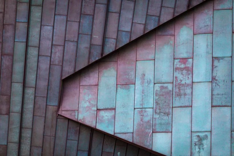Dachfläche aus Metallpaneelen mit Patina und einer scharfen Kante. Beispielfoto.